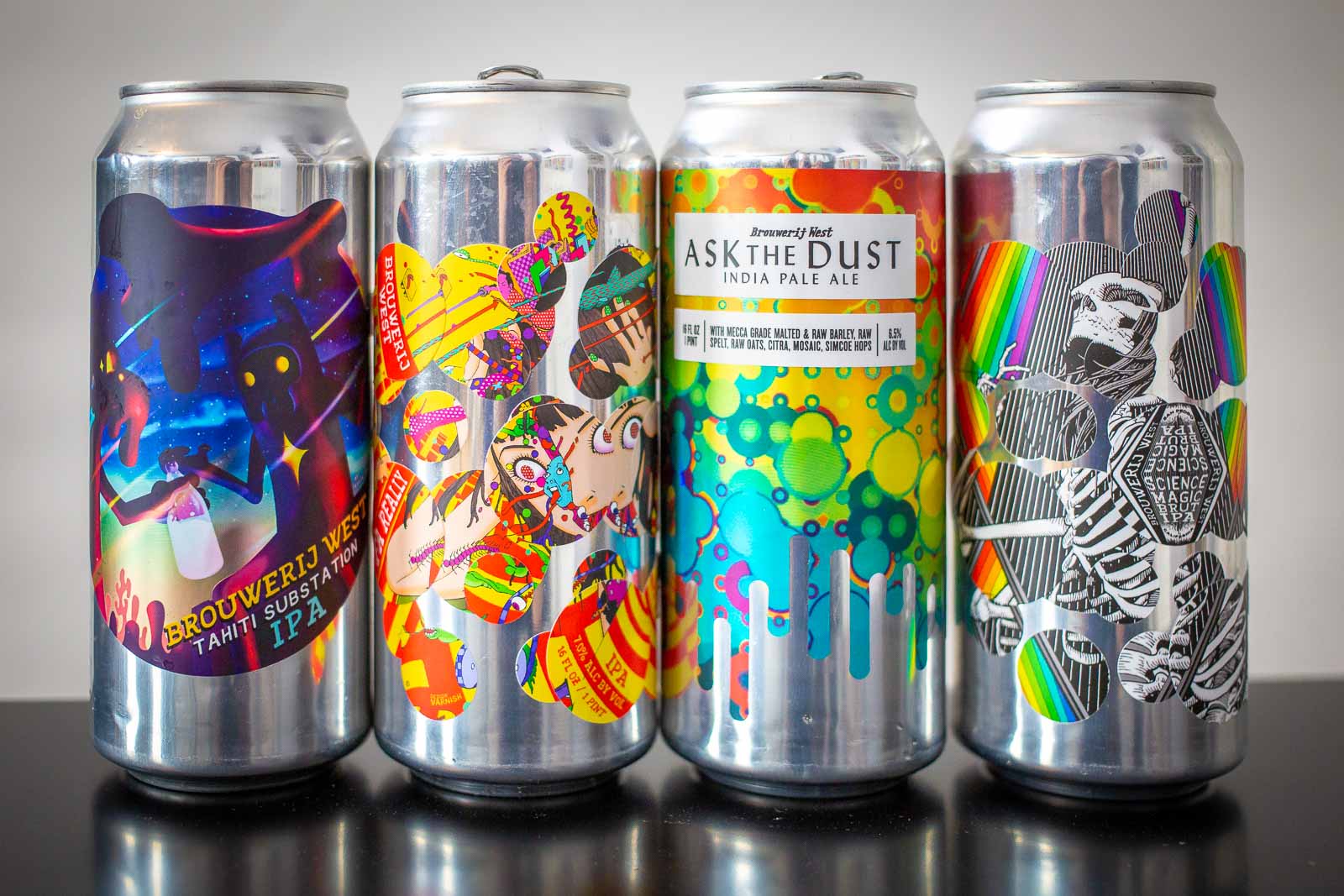 Four beer cans with colorful labels from Brouwerij West on a white background.
