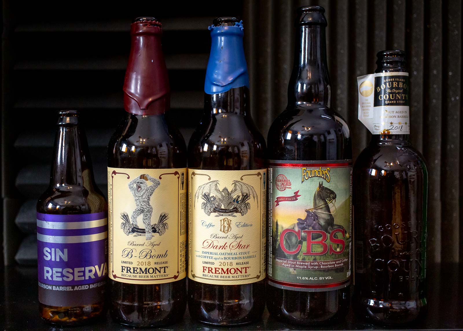 Pictured: Five bottles of barrel-aged beer from Trustworthy Brewing, Fremont Brewing, Founders Brewing, and Goose Island