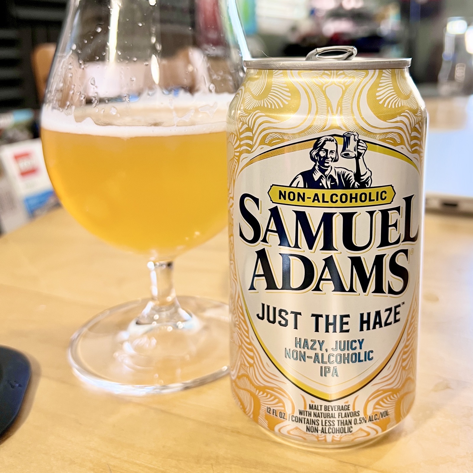 Pictured: A can of Just The Haze next to a glass of yellow beer on the table in the four brewers studio.